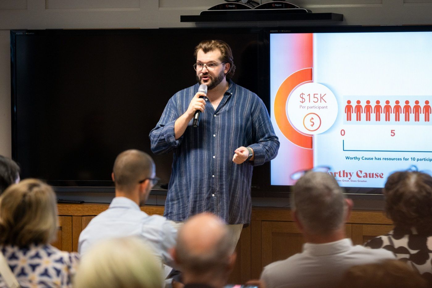 Rick Cohen gesturing mid-talk in front of a Worthy Cause impact slide