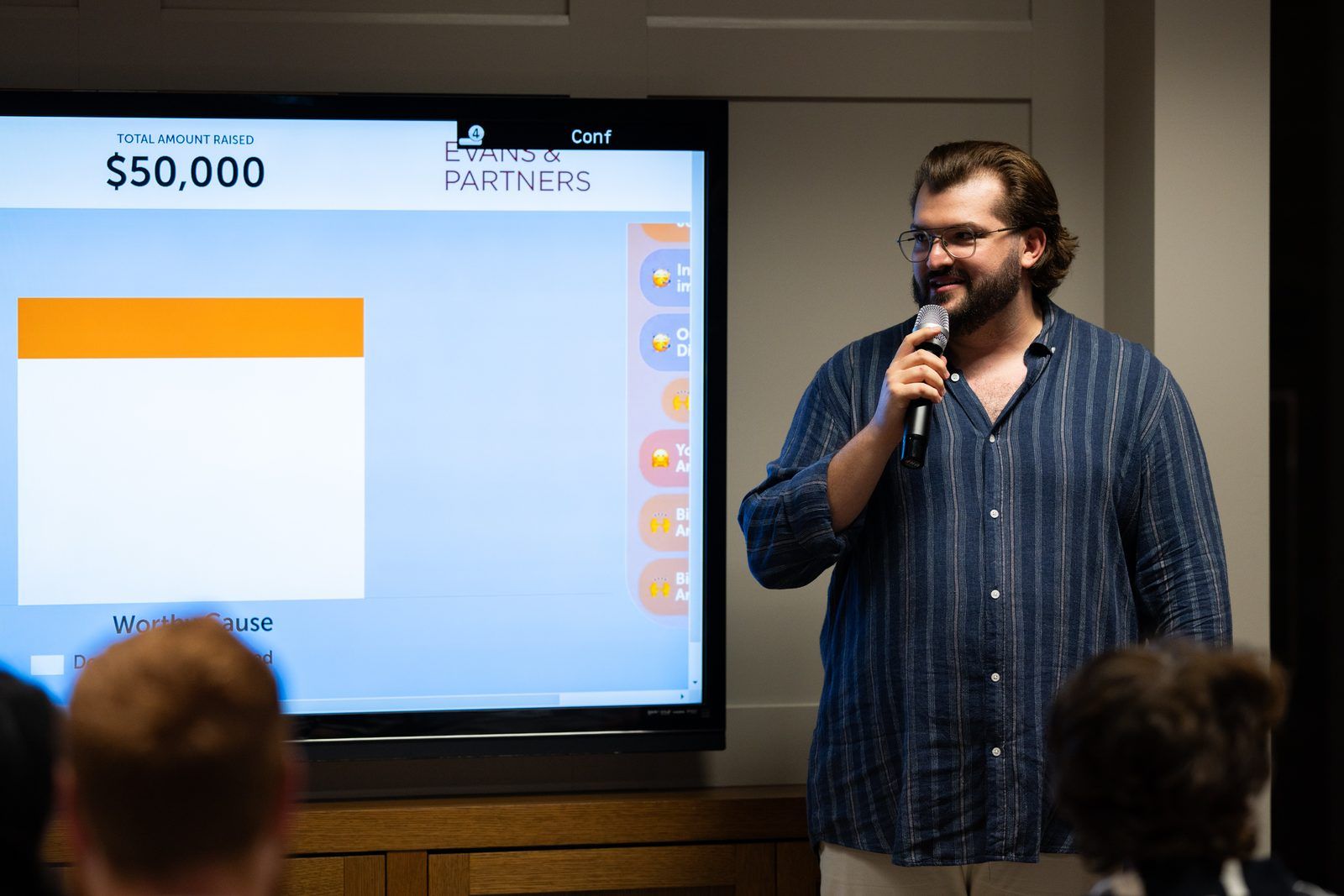 Rick Cohen at the microphone beside the fundraising total on screen