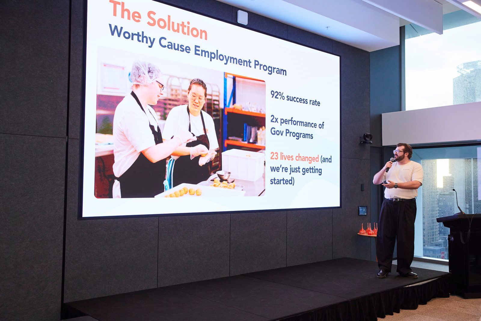 Rick Cohen presenting a slide on stage to the audience