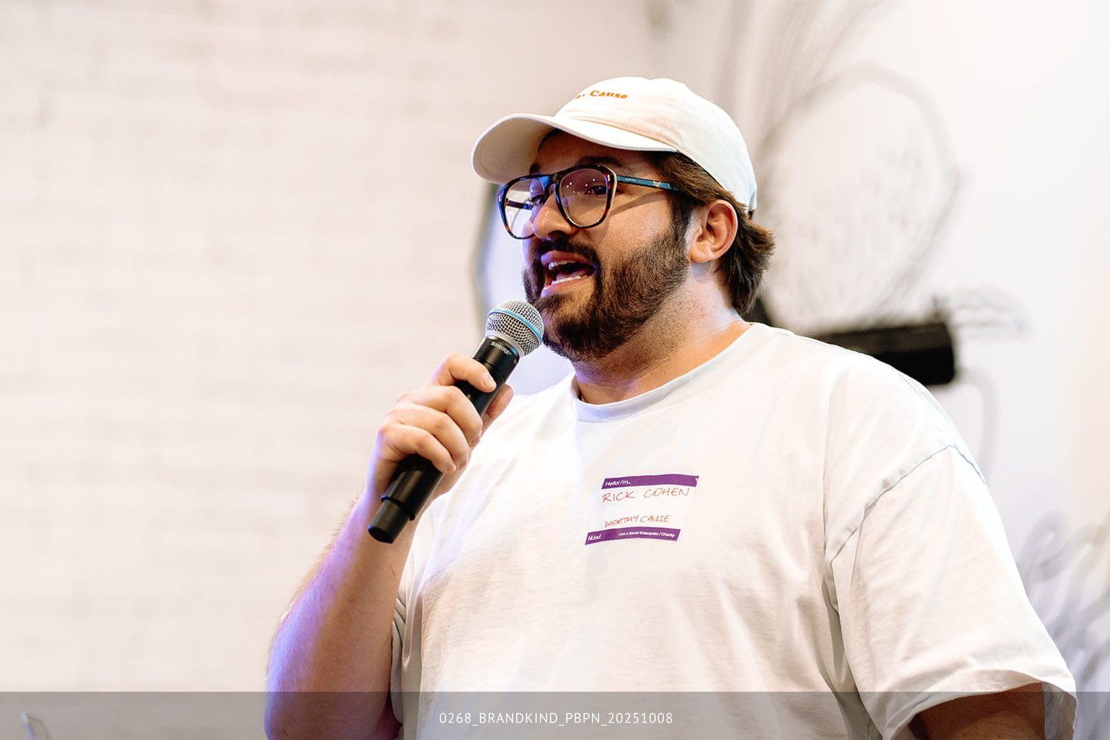 Rick Cohen smiling at the microphone during a community talk